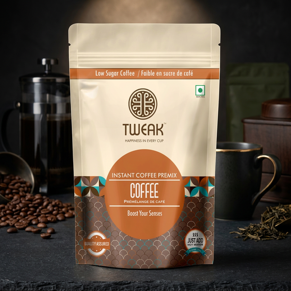 A stand-up pouch of Tweak Instant Coffee Premix on a dark tabletop with coffee beans, a French press, and a mug in the background.
